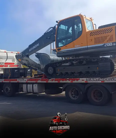 Escavadeira transportada na plataforma do Auto Socorro MG